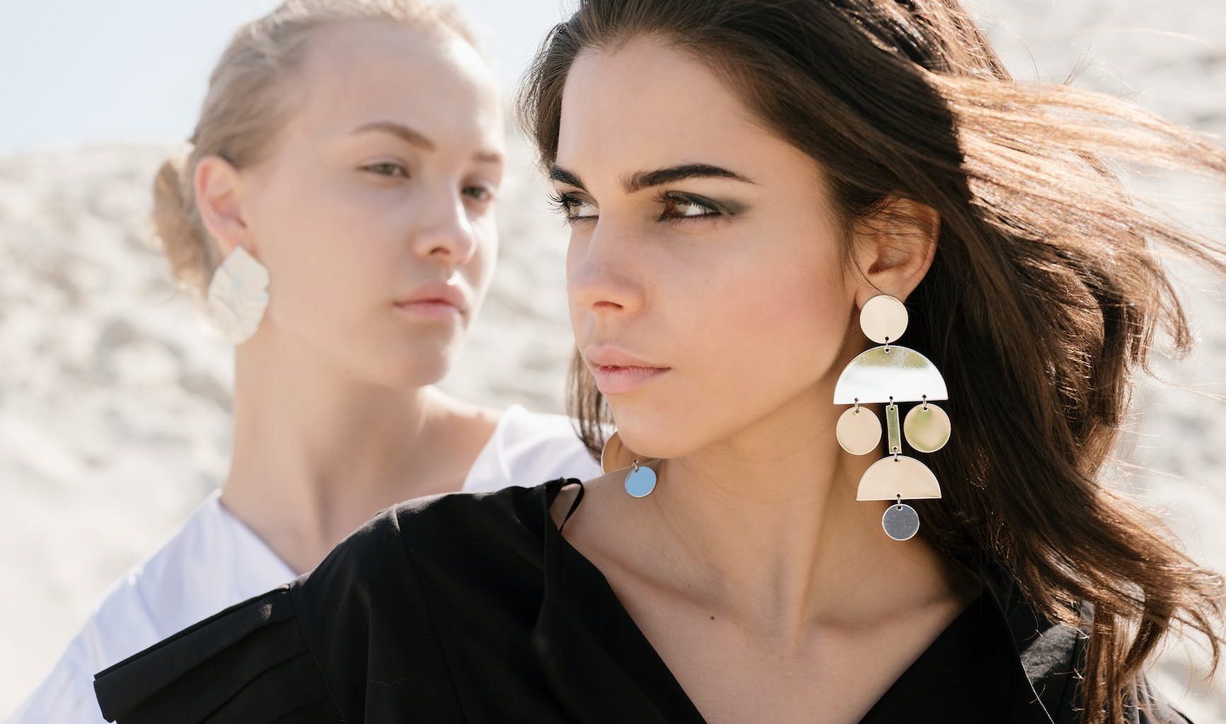 young women with contrast appearance on sandy beach