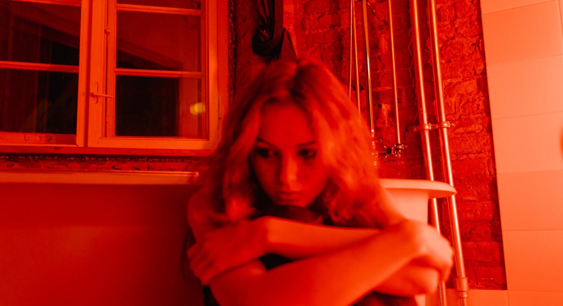 a woman sitting beside the bathtub