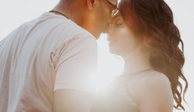 man wearing white shirt kissing woman in her nose